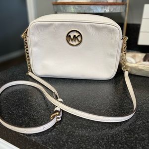 Michael Kors ivory leather crossbody with gold chain detail on strap.